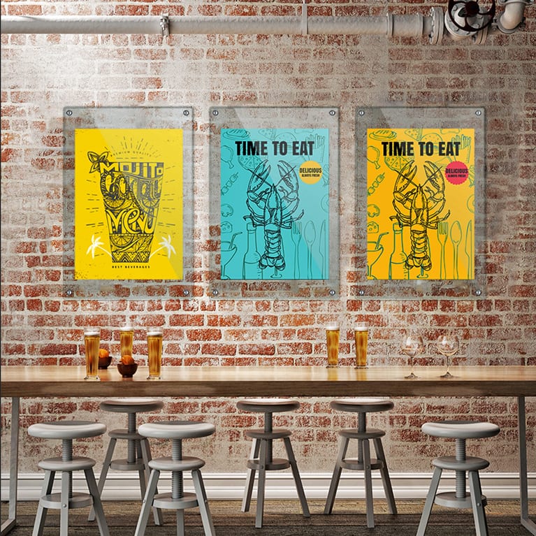 Three glass-framed wall banners on a brick wall